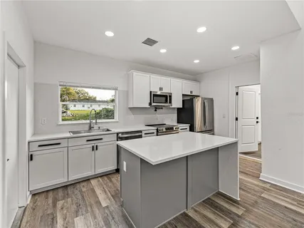 a kitchen with appliances a sink and cabinets