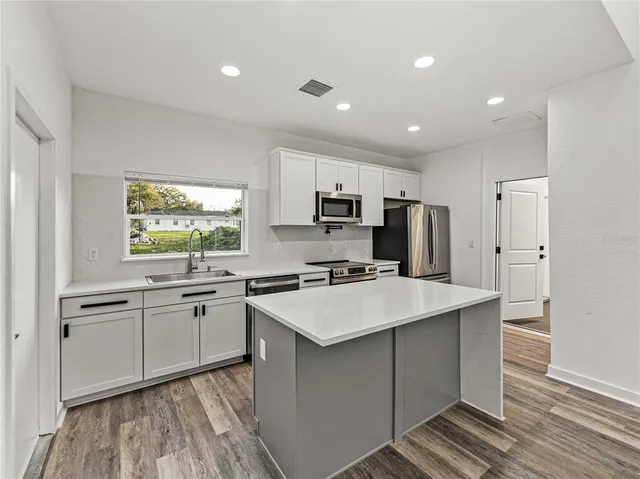 a kitchen with appliances a sink and cabinets