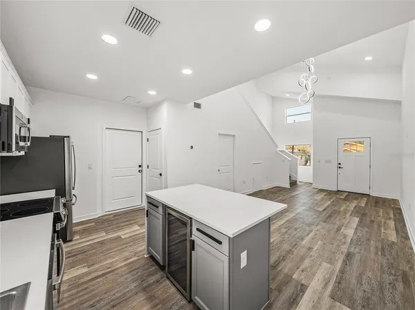 an empty room with wooden floor and hallway