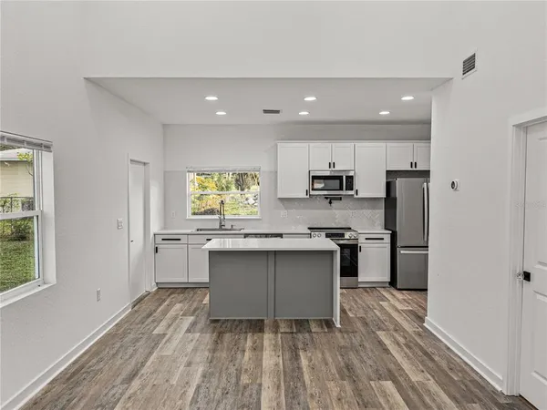 a kitchen with stainless steel appliances granite countertop a sink stove and refrigerator