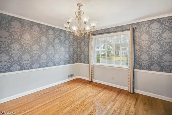 a view of a big room with wooden floor and windows