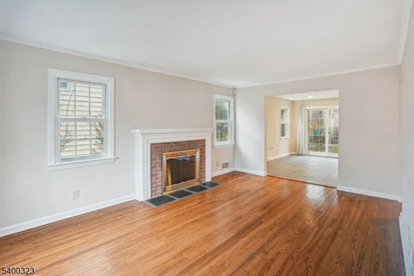 a view of empty room with wooden floor and fireplace