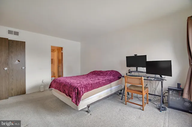 a large bed sitting in a bedroom next to a window