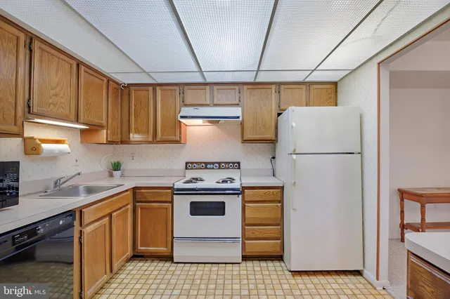 a kitchen with a refrigerator sink stove and cabinets