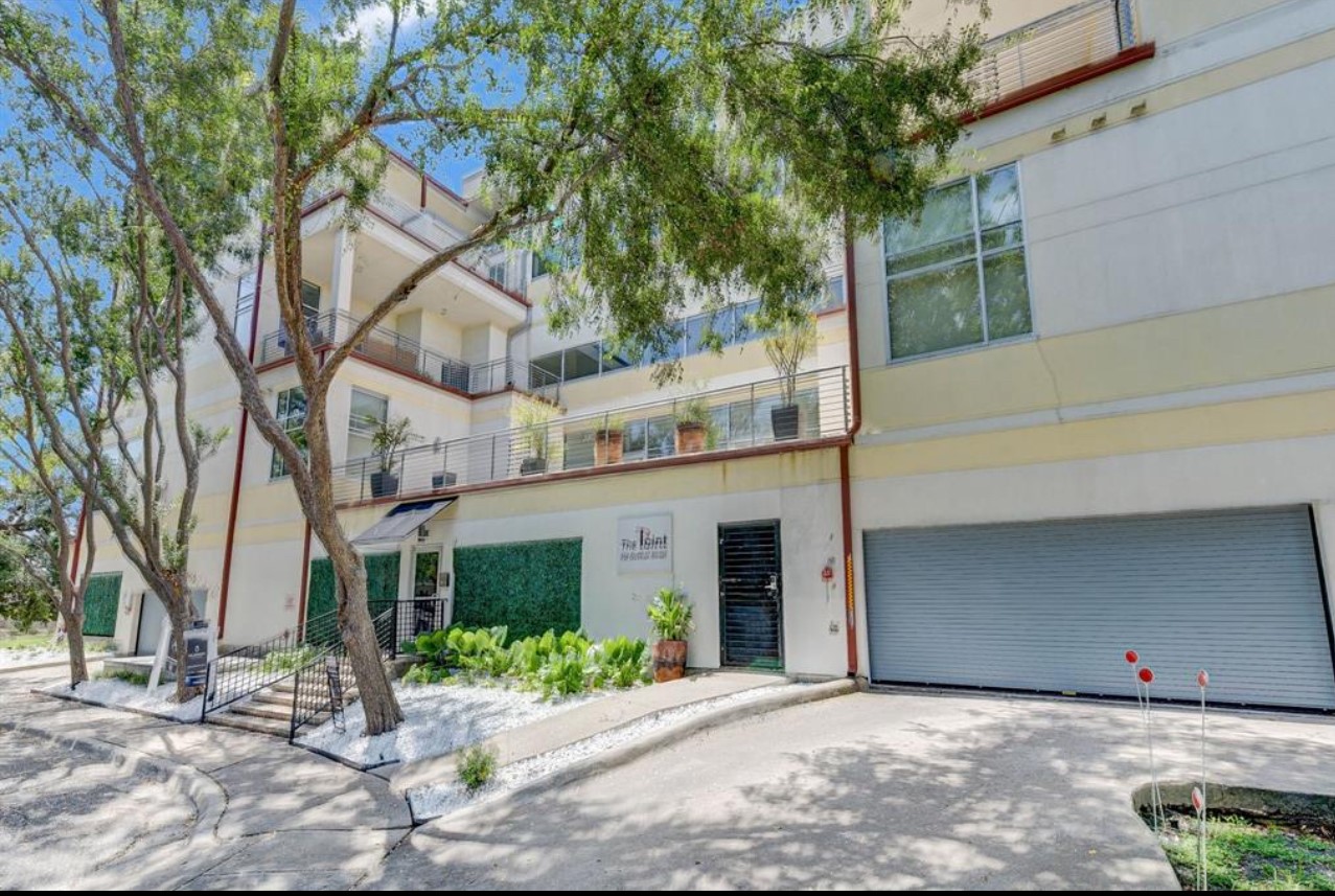 102 Quitman Street, Unit 301 Houston, TX 77009 - Photo 1 of 33 a front view of a building with a garden and trees