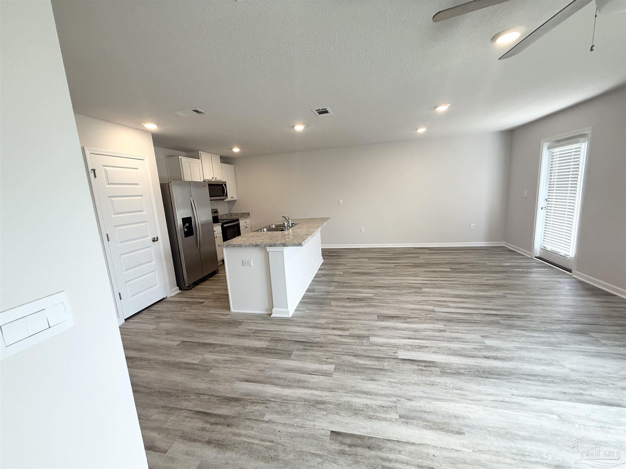 4335 Redbay Court Pace, FL 32571 - Photo 12 of 30 a view of a big room with wooden floor and windows