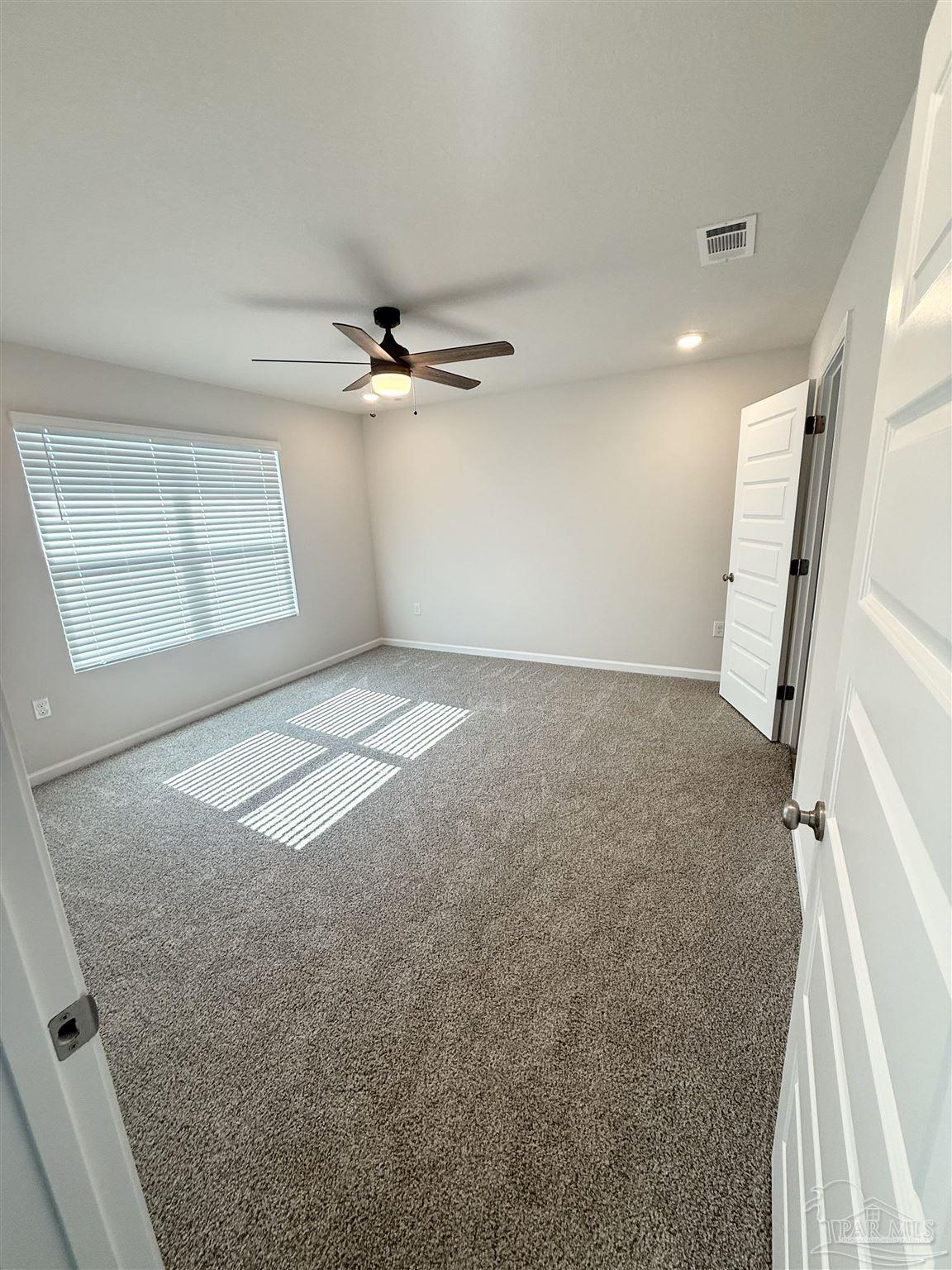 4335 Redbay Court Pace, FL 32571 - Photo 17 of 30 an empty room with a ceiling fan and windows