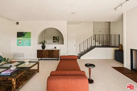 a living room with furniture fireplace and a large window