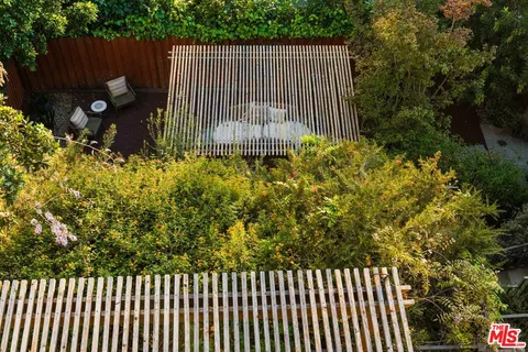 a view of a backyard with table and chairs with wooden fence