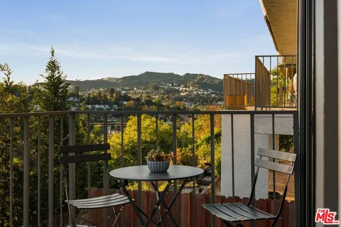 a view of a balcony with furniture and next to a window