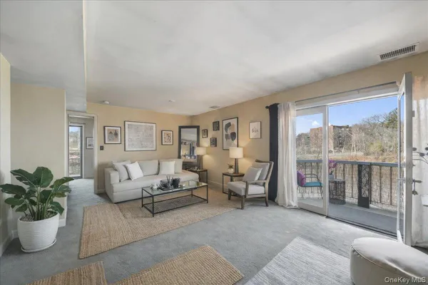 a living room with fireplace furniture and a potted plant