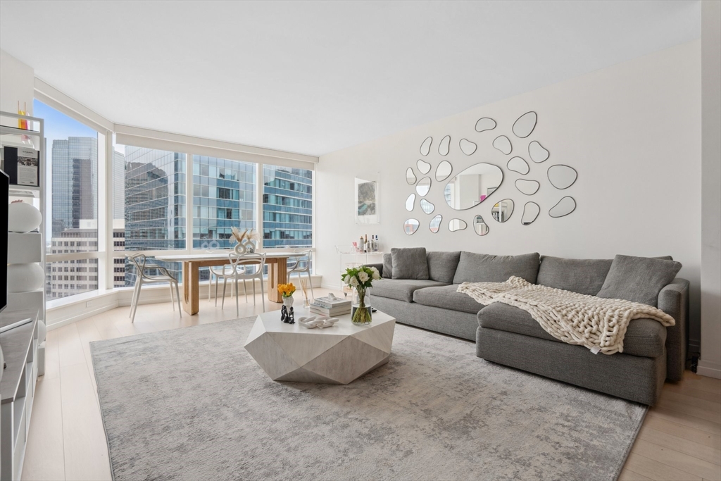 1 Franklin Street, Unit 2507 Boston, MA 02110 - Photo 1 of 37 a living room with furniture and a large window