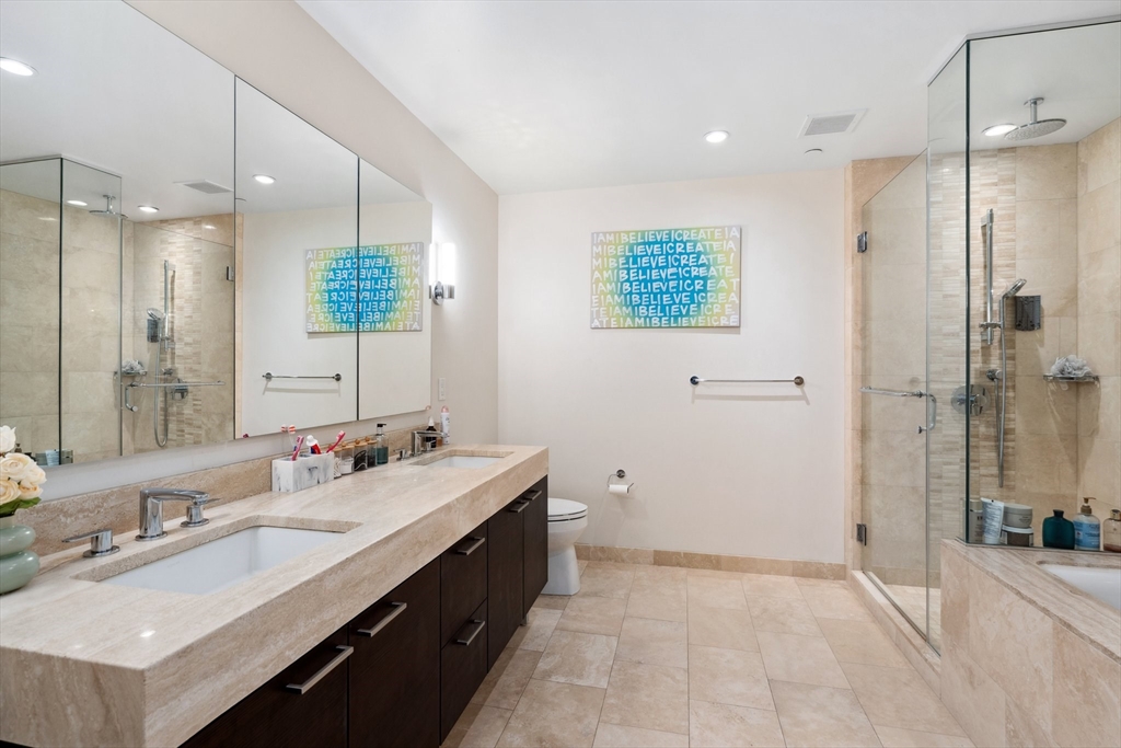 1 Franklin Street, Unit 2507 Boston, MA 02110 - Photo 15 of 37 a bathroom with a double vanity sink mirror and shower