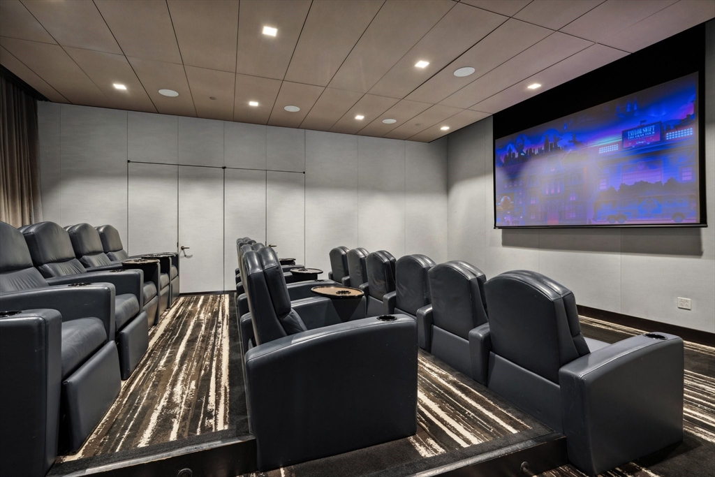 1 Franklin Street, Unit 2507 Boston, MA 02110 - Photo 28 of 37 a media room with lots of chairs and a projector screen