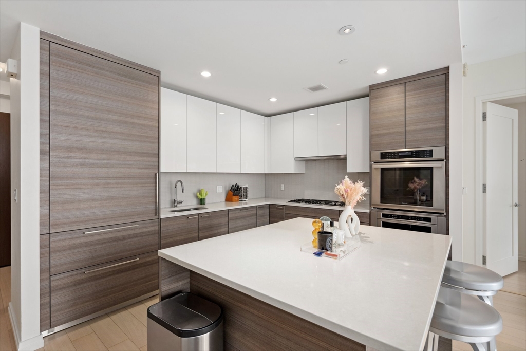 1 Franklin Street, Unit 2507 Boston, MA 02110 - Photo 4 of 37 a kitchen with kitchen island a sink appliances and cabinets