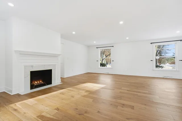 a view of empty room with wooden floor and fireplace