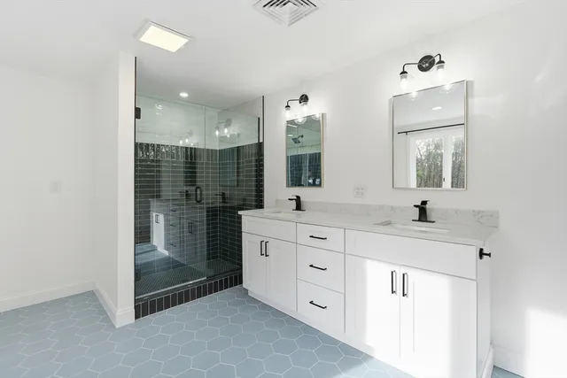 a bathroom with a double vanity sink mirror and shower