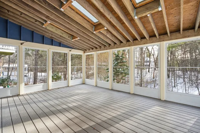 a view of an empty room with wooden floor and fence