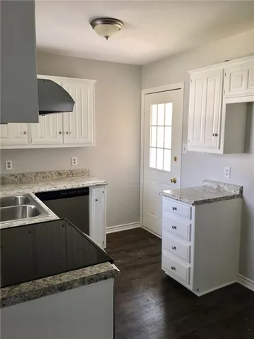 a kitchen with granite countertop a sink and a stove