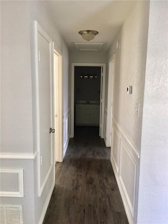 1005.5 Pine Street, Unit 1005 5 McKinney, TX 75069 - Photo 6 of 11 a view of a hallway with a wooden floor
