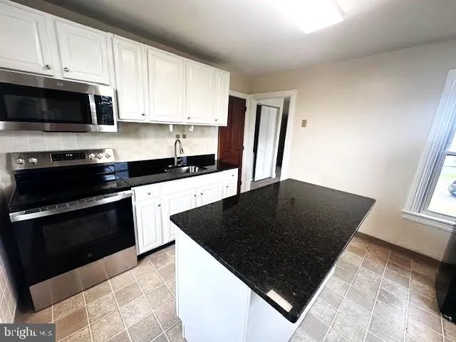 a kitchen with granite countertop a stove and a sink