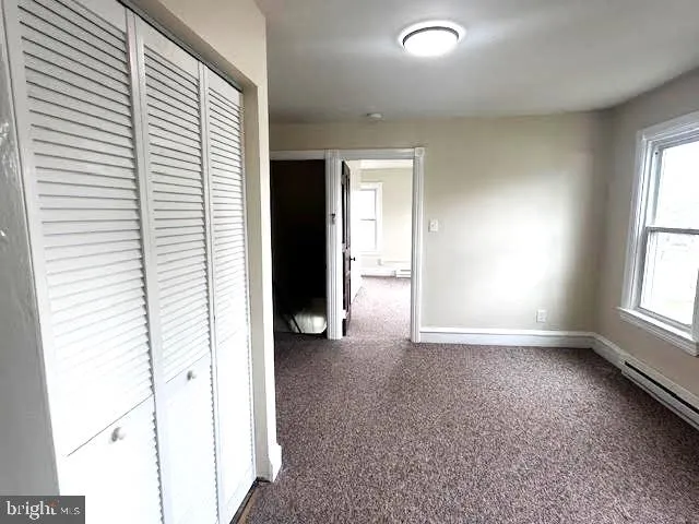 an empty room with windows and closet