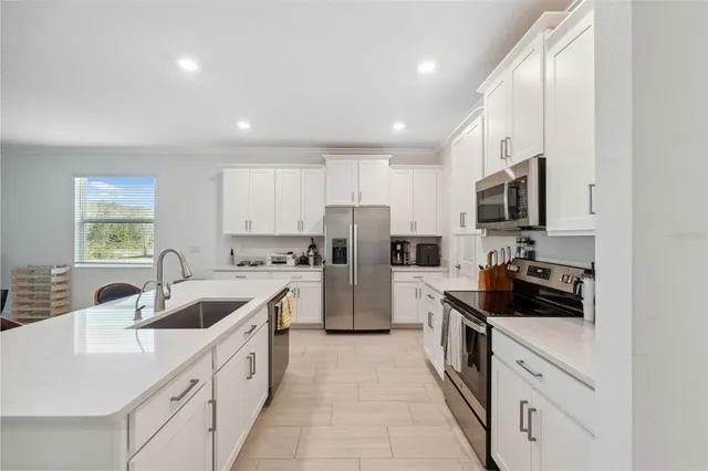 a kitchen with kitchen island a sink a stove and refrigerator