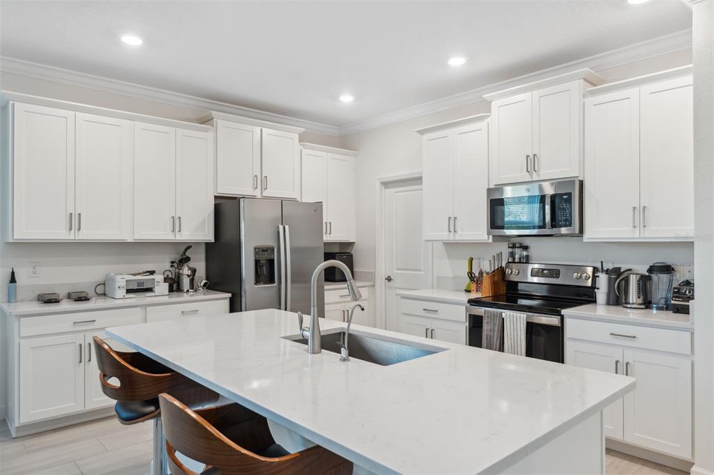 16787 Shell Bay Drive Land O Lakes, FL 34638 - Photo 7 of 54 a kitchen with kitchen island a sink a stove and refrigerator