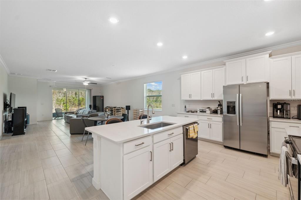 16787 Shell Bay Drive Land O Lakes, FL 34638 - Photo 10 of 54 a kitchen with a sink a stove a refrigerator and white cabinets