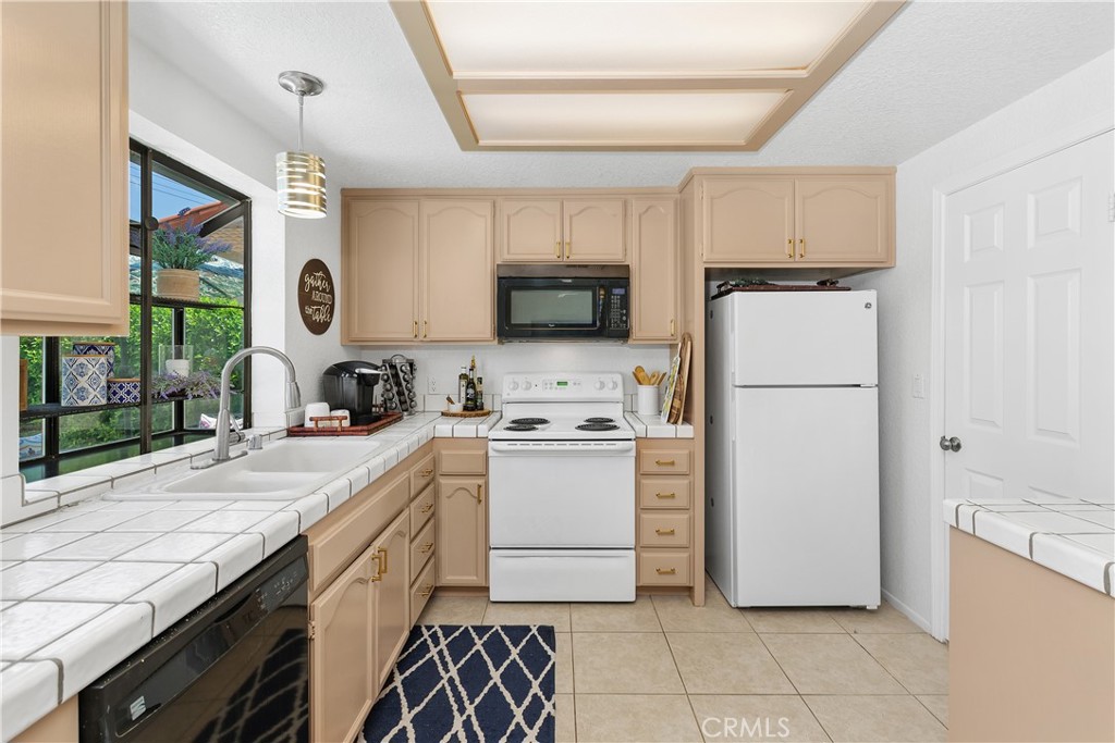 78680 Saguaro Road La Quinta, CA 92253 - Photo 12 of 30 a kitchen with a refrigerator a stove top oven and a sink