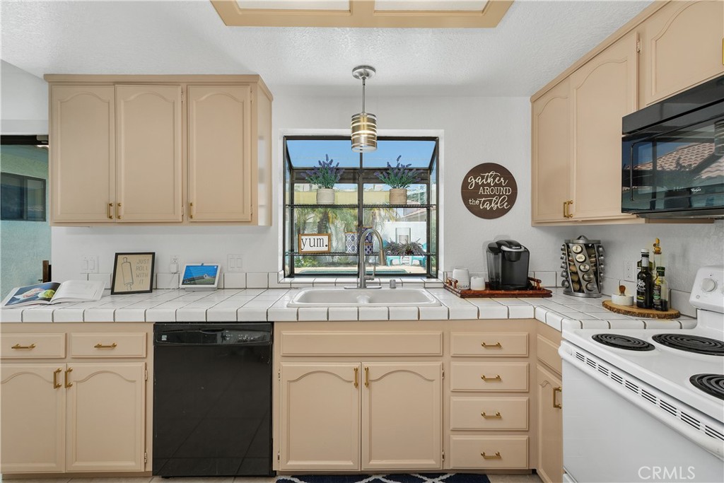 78680 Saguaro Road La Quinta, CA 92253 - Photo 13 of 30 a kitchen with granite countertop white cabinets white stainless steel appliances and a window