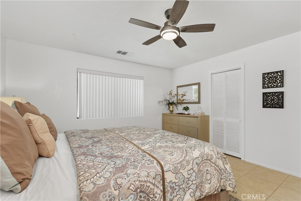 78680 Saguaro Road La Quinta, CA 92253 - Photo 21 of 30 a bedroom with a bed and a chandelier