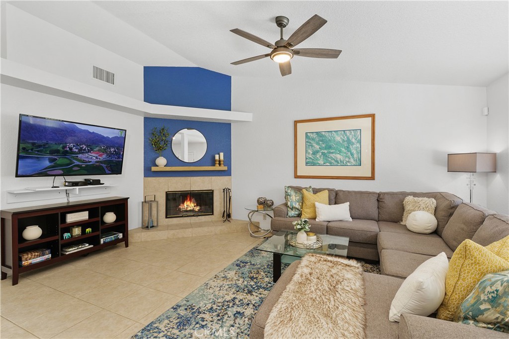 78680 Saguaro Road La Quinta, CA 92253 - Photo 6 of 30 a living room with furniture a fireplace and a flat screen tv