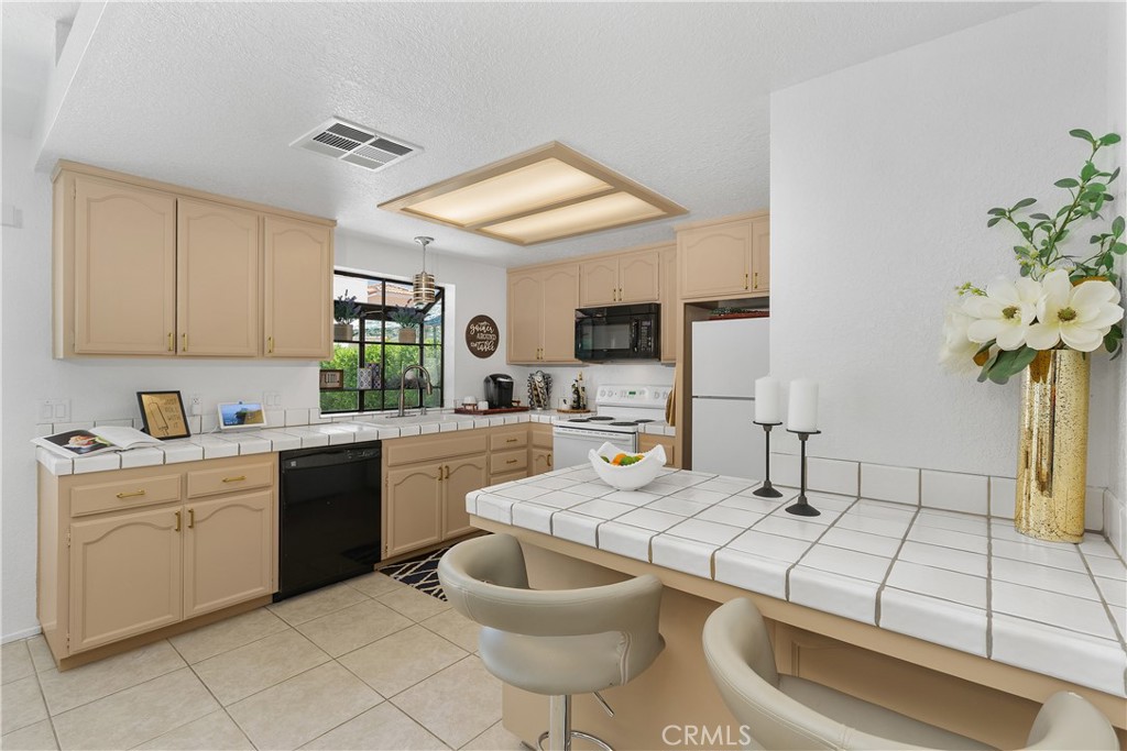 78680 Saguaro Road La Quinta, CA 92253 - Photo 10 of 30 a kitchen with a sink appliances and cabinets