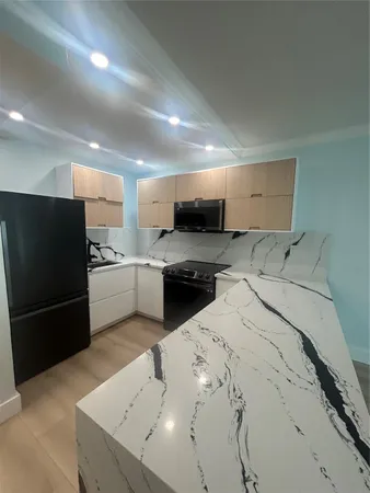 a kitchen with a refrigerator and a stove top oven