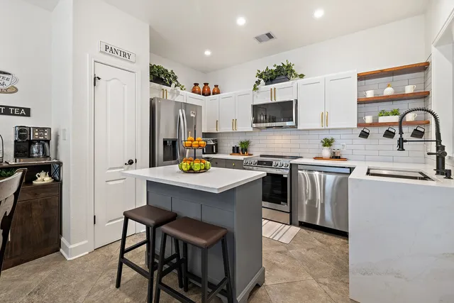 a kitchen with a sink refrigerator and microwave