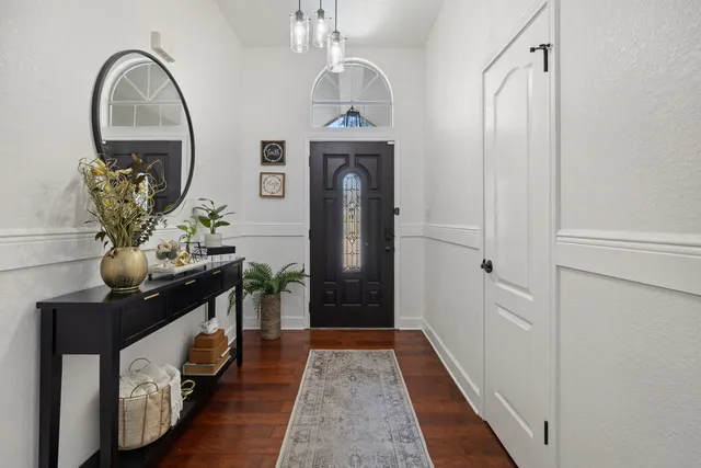 a hallway with painting on the wall and a mirror