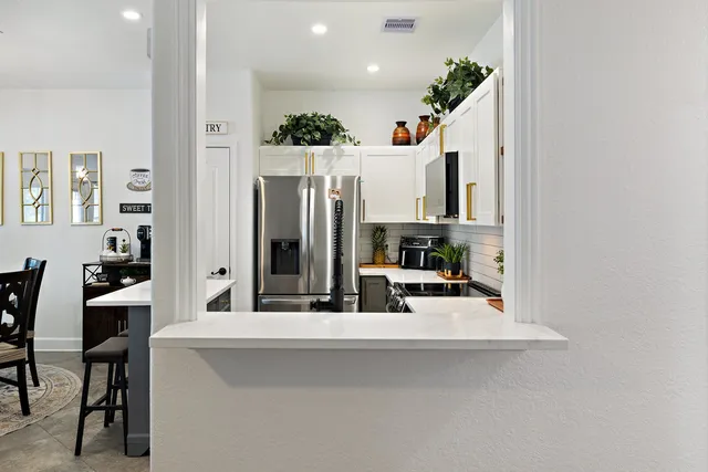 a kitchen with stainless steel appliances kitchen island granite countertop a refrigerator and microwave