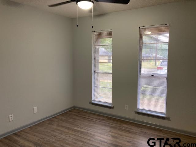 320 Blake Drive Longview, TX 75604 - Photo 8 of 9 an empty room with wooden floor and windows
