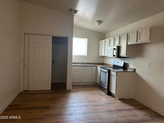 a kitchen with a refrigerator and a stove top oven