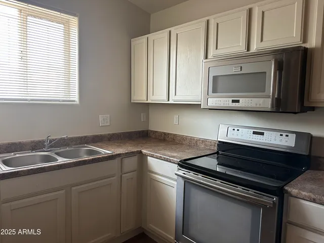 a kitchen with granite countertop white cabinets and a stove top oven