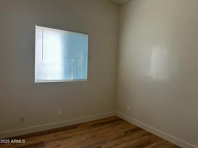 a view of a small space with wooden floor and a window