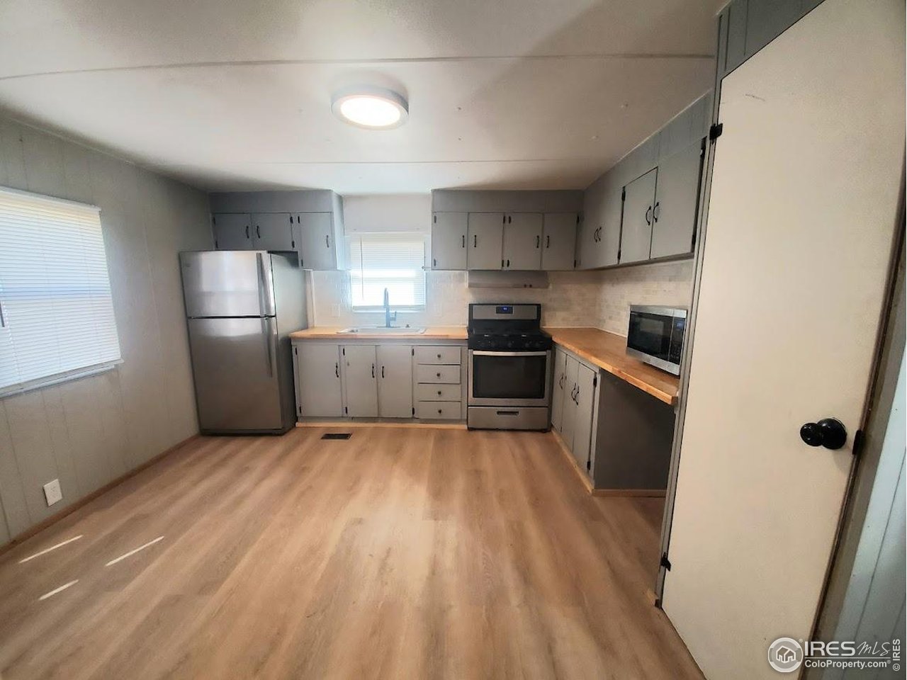 1212 Butte Road, Unit 20 Loveland, CO 80537 - Photo 6 of 22 a large kitchen with a wooden floor and stainless steel appliances