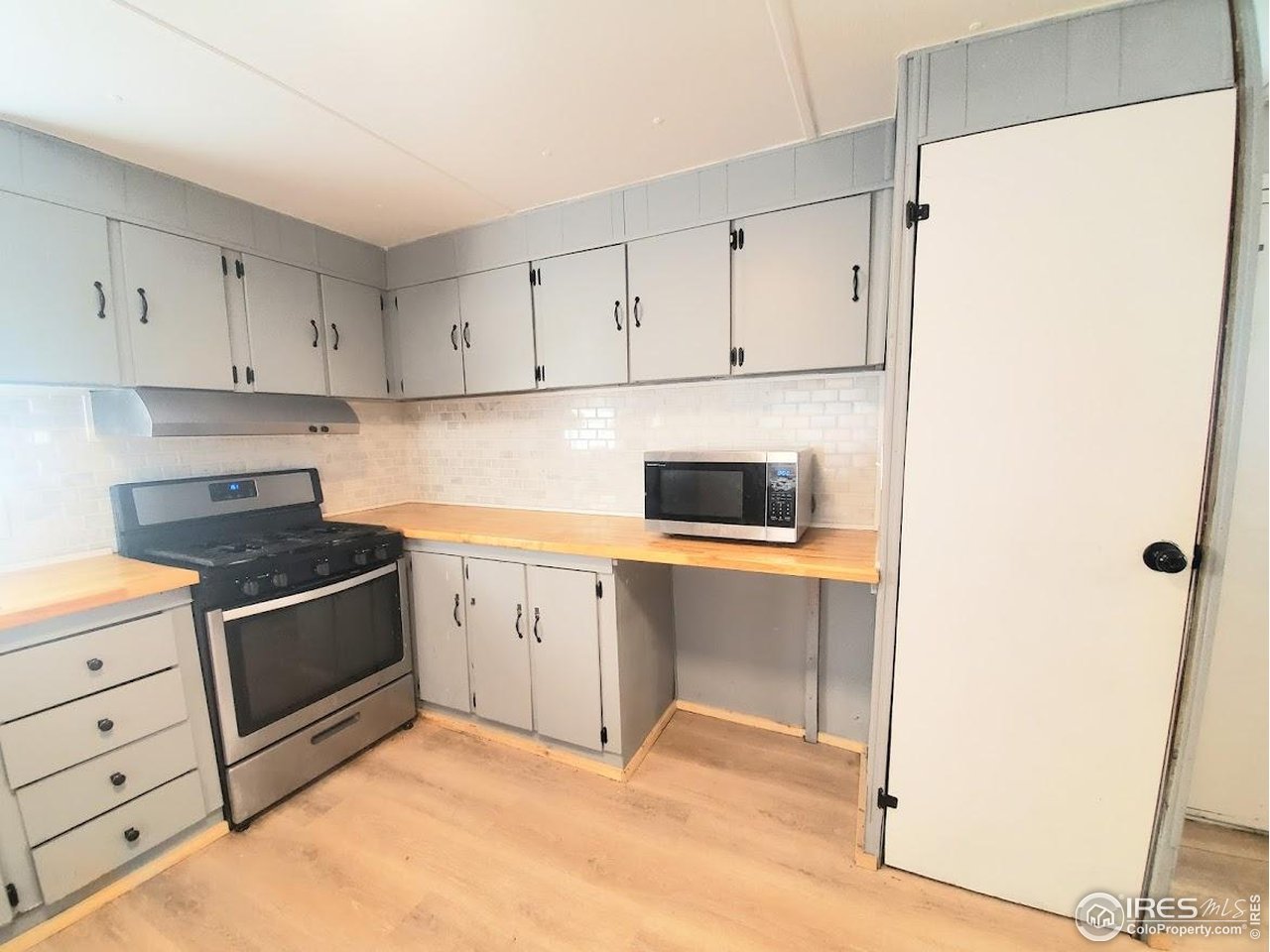 1212 Butte Road, Unit 20 Loveland, CO 80537 - Photo 7 of 22 a kitchen with white cabinets and white appliances