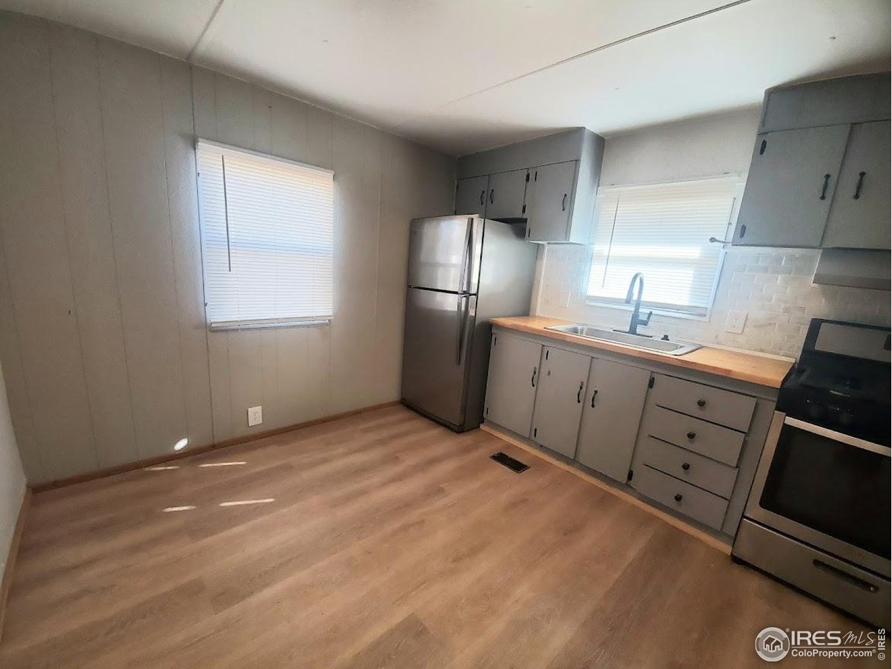 1212 Butte Road, Unit 20 Loveland, CO 80537 - Photo 9 of 22 a kitchen with white cabinets and white appliances