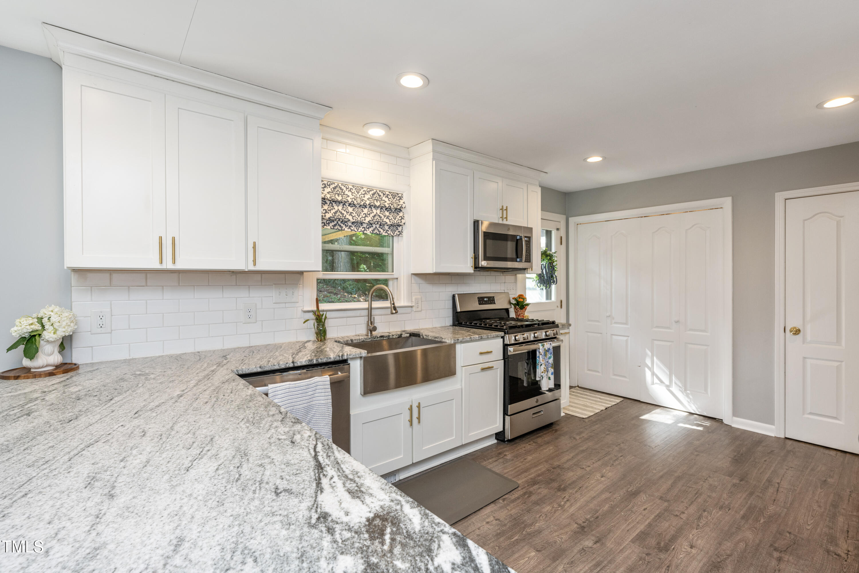 724 Hunting Ridge Road Raleigh, NC 27615 - Photo 11 of 24 a kitchen with stainless steel appliances granite countertop a stove a sink and a microwave