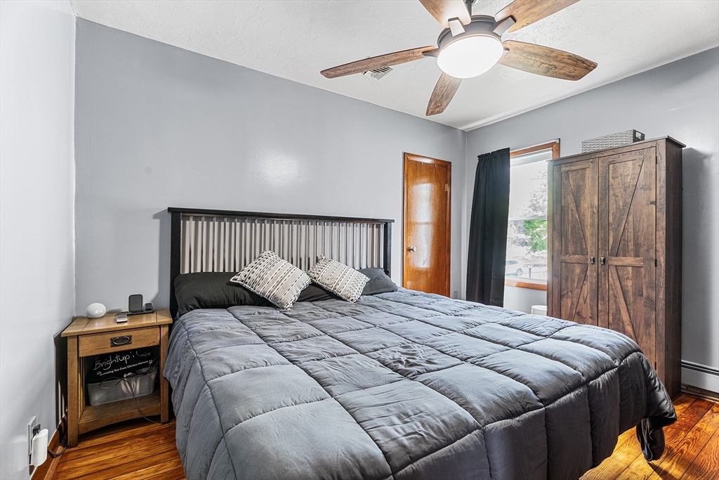 51 Cherry Street Fairhaven, MA 02719 - Photo 14 of 27 a bedroom with a bed and a chandelier