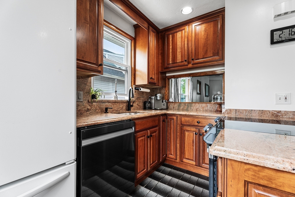 51 Cherry Street Fairhaven, MA 02719 - Photo 3 of 27 a kitchen with granite countertop wooden cabinets and white appliances