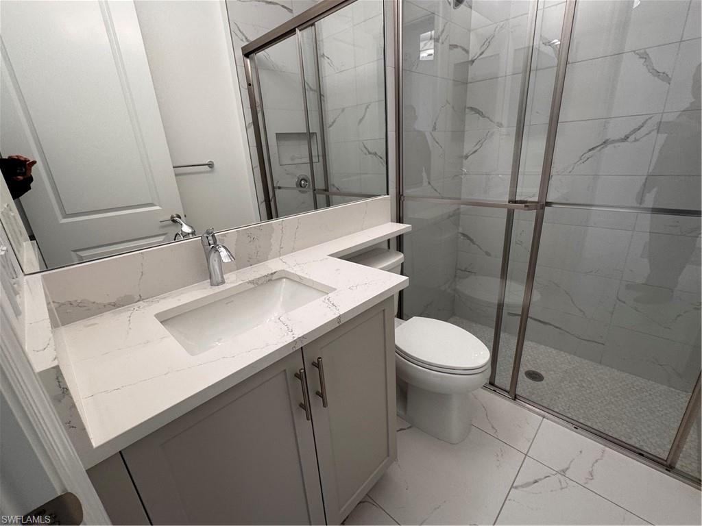 2864 Bloomfield Way Naples, FL 34112 - Photo 17 of 40 a bathroom with a sink a toilet and shower