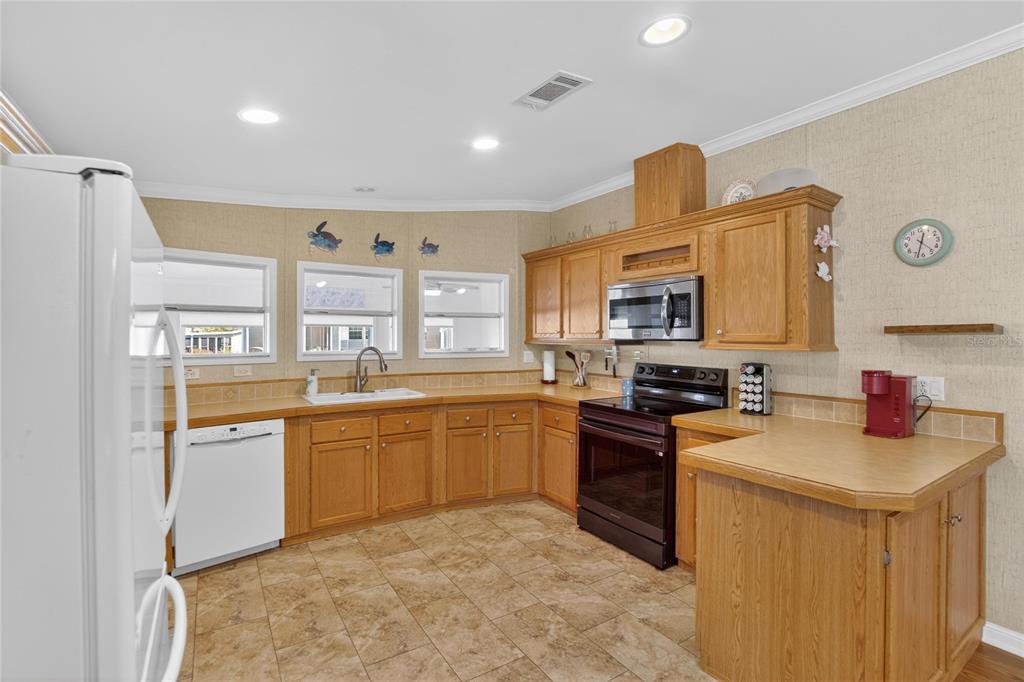 37526 Rio Lane Zephyrhills, FL 33541 - Photo 19 of 58 a kitchen with stainless steel appliances granite countertop a sink stove and refrigerator